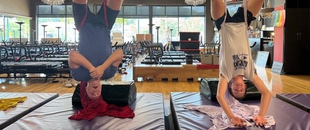 Home Two people performing a Hip Hang